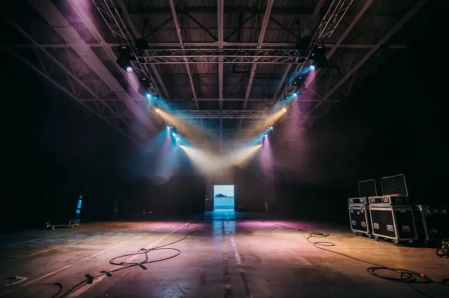 Galpón de eventos con estructuras de iluminación encendidas