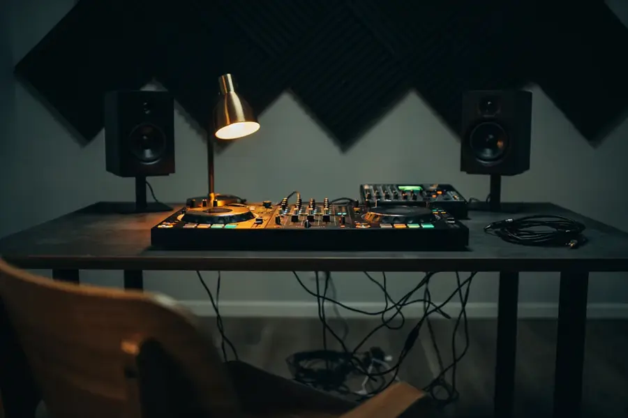 Cabina de música con controlador y monitores en penumbra